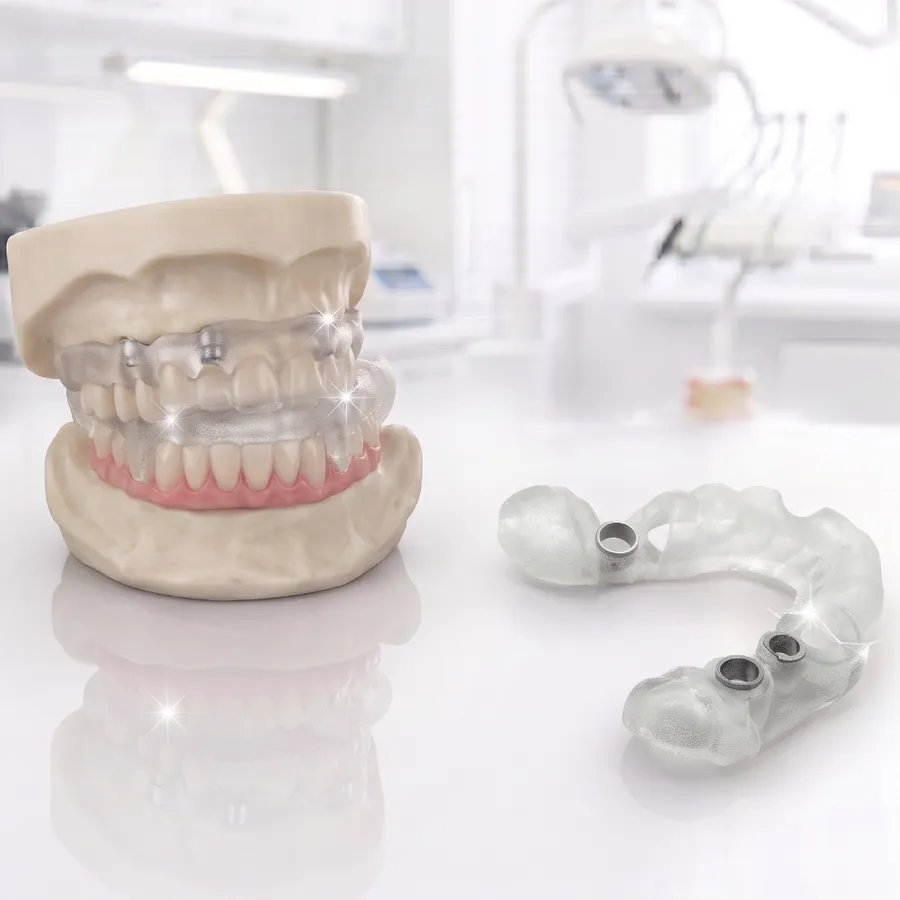 Clear 3D-printed surgical guide with metal sleeves beside a jaw model